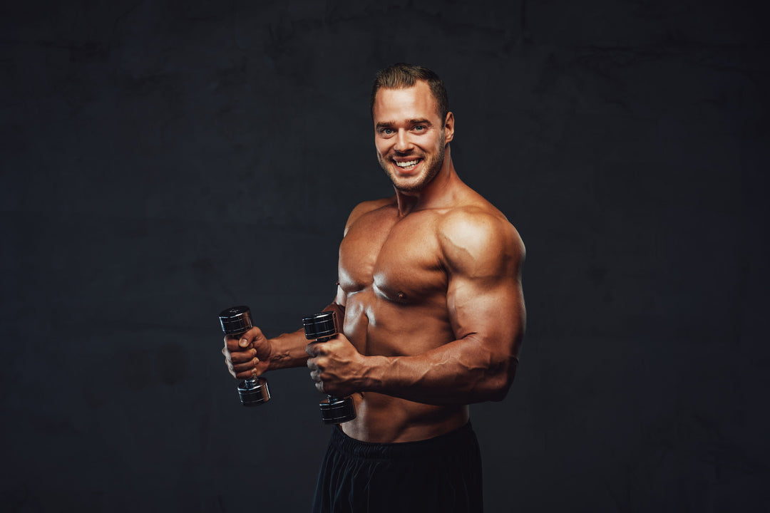 Handsome brutal bodybuilder posing with dumbbells